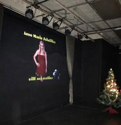 MILF and Cookies on stage, with a Christmas tree beside the screen