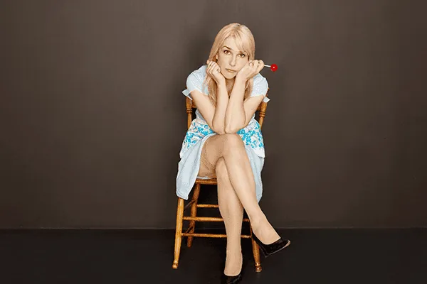 Anne Marie on a wooden chair, chin in hands